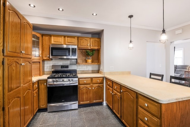 kitchen with a kitchen breakfast bar, hanging light fixtures, kitchen peninsula, stainless steel appliances, and crown molding