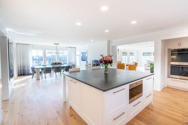 61 Chickering Rd, Spencer, MA 01562 - kitchen with stainless steel double oven, dark countertops, light wood-type flooring, recessed lighting, and a kitchen island