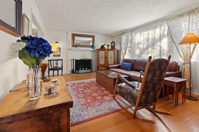 living room featuring wood-type flooring, a fireplace, and ornamental molding