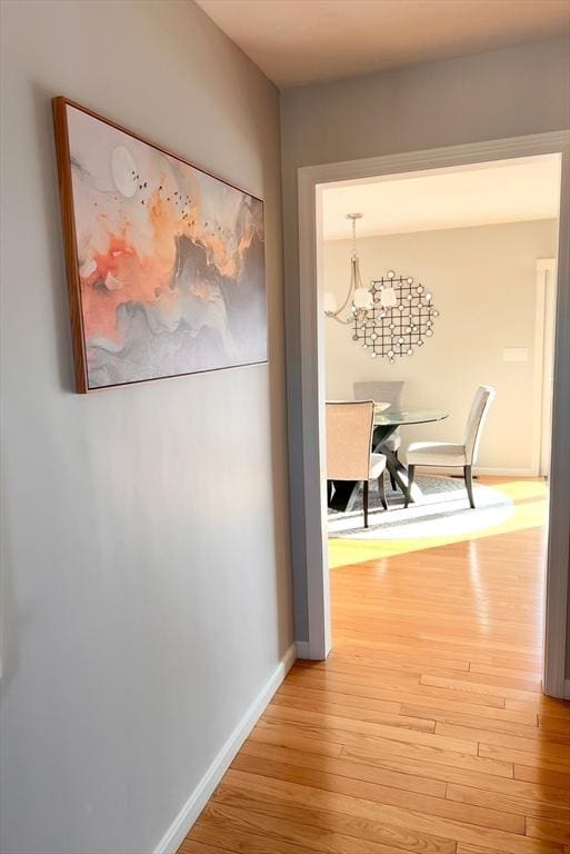 hall featuring an inviting chandelier and light hardwood / wood-style flooring