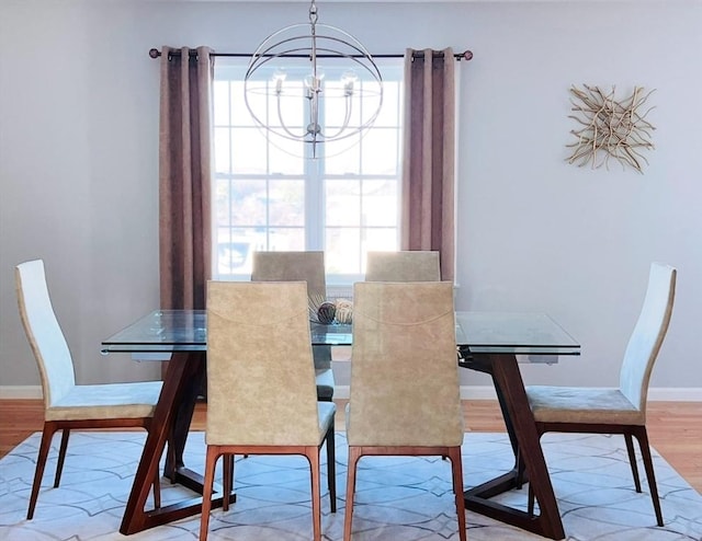 dining area with plenty of natural light, light hardwood / wood-style flooring, and a notable chandelier