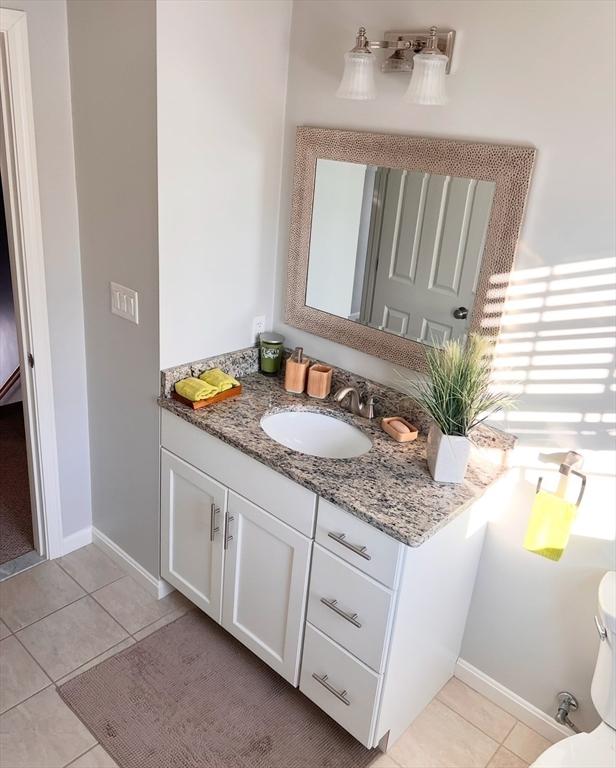 bathroom featuring tile patterned flooring, vanity, and toilet