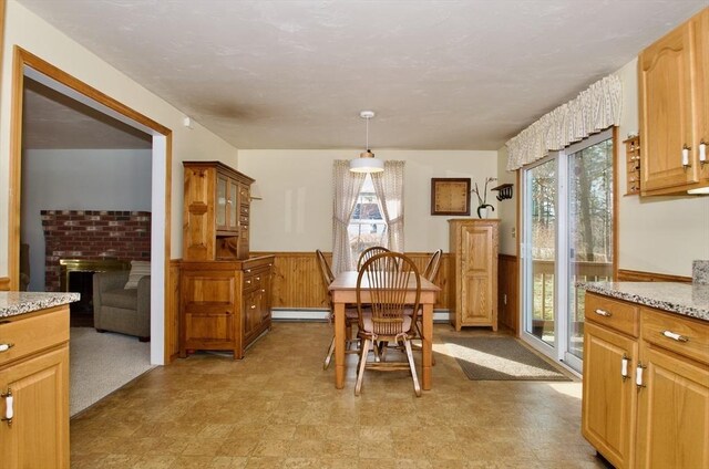 dining area with a brick fireplace and a baseboard heating unit