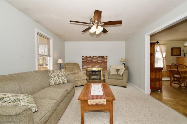 living room with carpet floors, a fireplace, ceiling fan, and baseboard heating