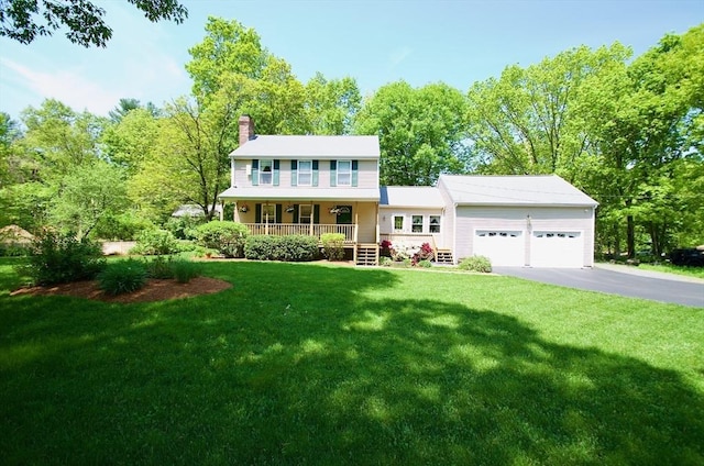 colonial home with a porch, a garage, and a front yard