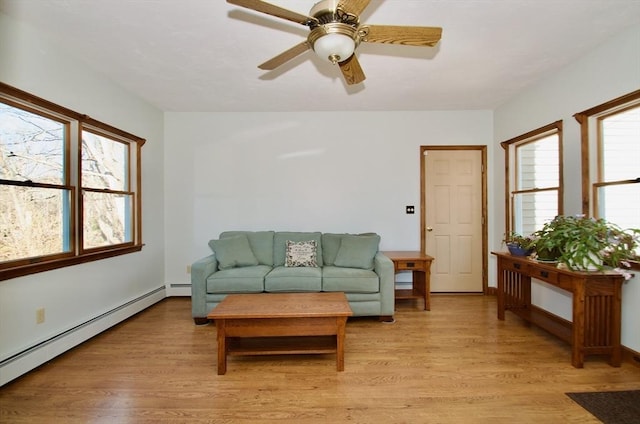 living room with a baseboard heating unit, light hardwood / wood-style floors, and ceiling fan