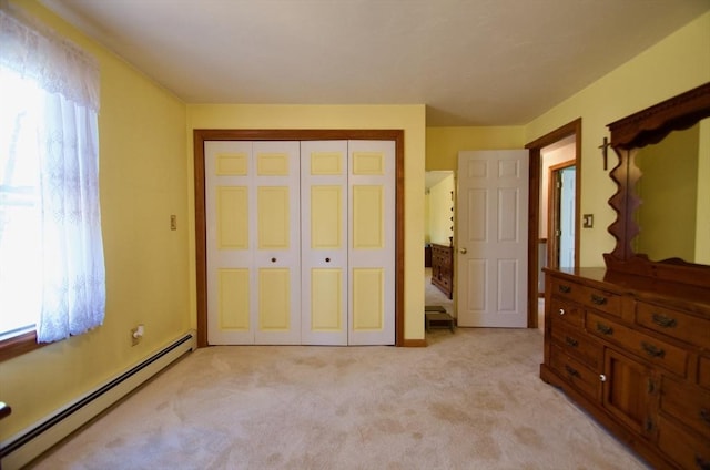 carpeted bedroom featuring multiple windows, a closet, and baseboard heating