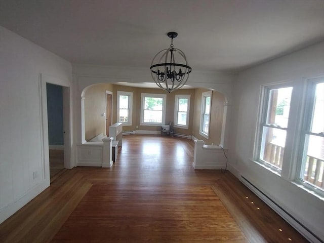 unfurnished dining area featuring an inviting chandelier, dark hardwood / wood-style flooring, and a baseboard heating unit