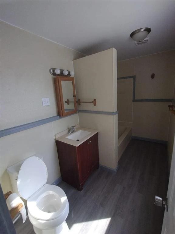 bathroom with vanity, wood-type flooring, walk in shower, and toilet