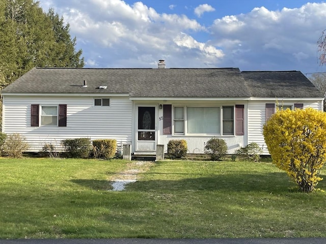 ranch-style house with roof with shingles, a chimney, and a front yard