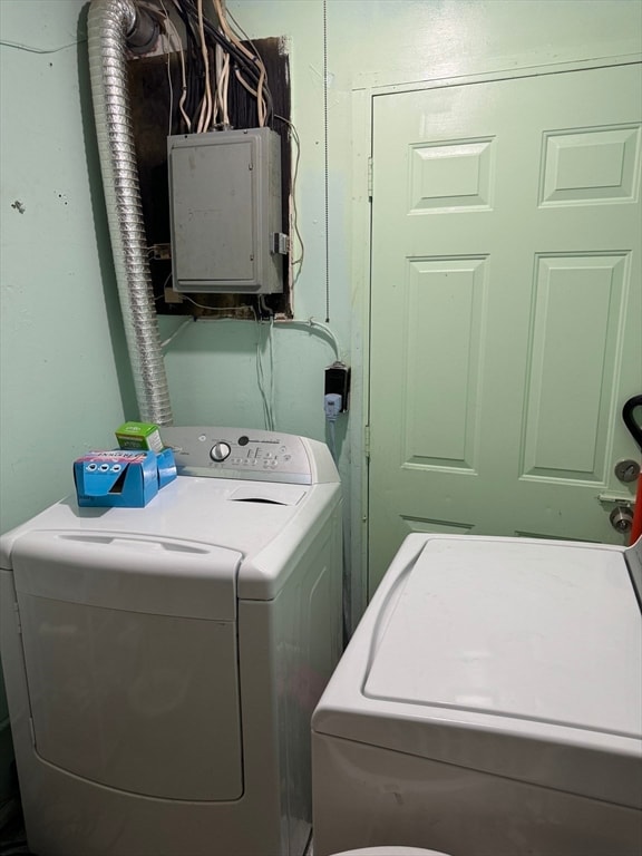 laundry room featuring electric panel and washing machine and clothes dryer