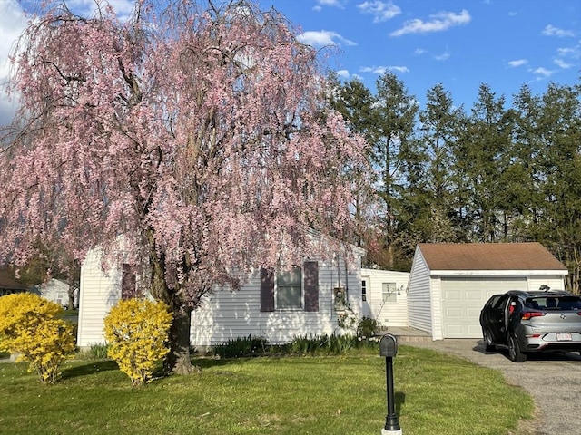 obstructed view of property featuring a garage, an outdoor structure, and a front lawn