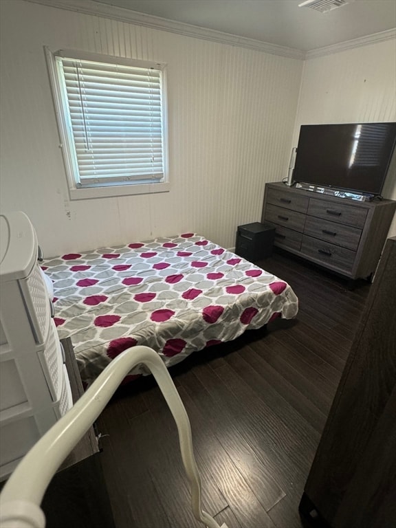 bedroom with crown molding and dark wood-type flooring