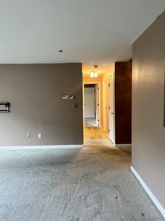 38 Dunham Rd Unit 303, Beverly, MA 01915 - unfurnished room featuring carpet, baseboards, and a textured ceiling