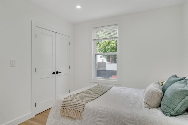 bedroom with light hardwood / wood-style flooring and a closet