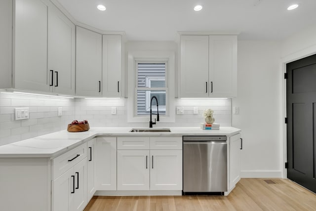 kitchen featuring dishwasher, light hardwood / wood-style flooring, sink, and white cabinets