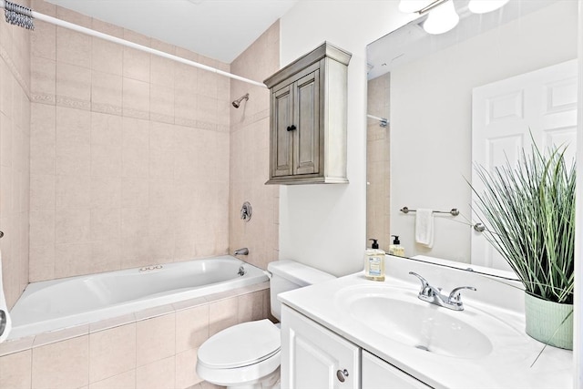 full bathroom featuring vanity, tiled shower / bath combo, and toilet