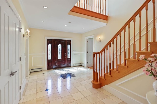 foyer entrance with light tile patterned floors, ornamental molding, and a baseboard radiator