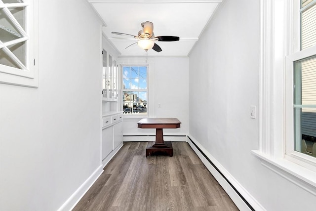 dining room featuring ceiling fan, ornamental molding, a baseboard radiator, and hardwood / wood-style floors