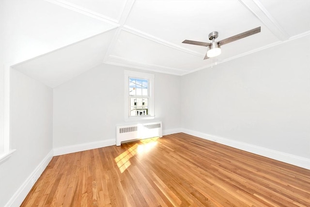 additional living space with ceiling fan, radiator heating unit, and light wood-type flooring