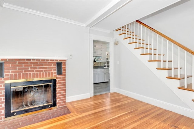 unfurnished living room featuring hardwood / wood-style floors, a fireplace, and ornamental molding