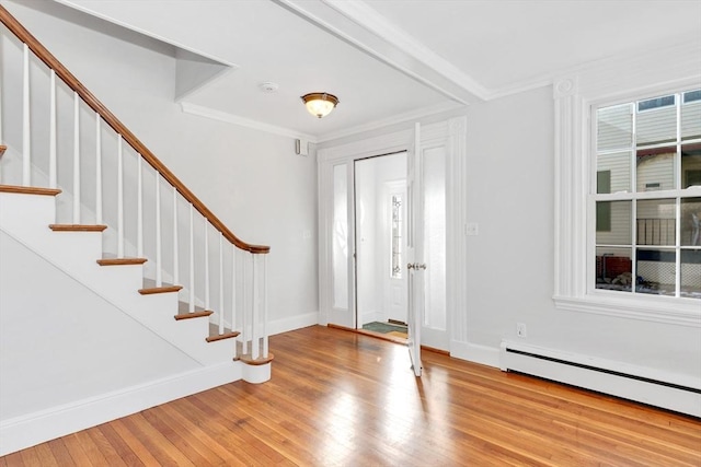 entrance foyer with a baseboard radiator, crown molding, and light hardwood / wood-style flooring