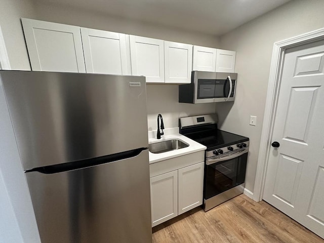 31 Horton St, Attleboro, MA 02703 - kitchen with appliances with stainless steel finishes, a sink, light wood-style floors, white cabinetry, and light countertops