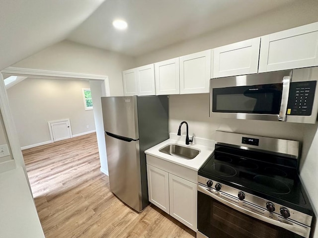 31 Horton St, Attleboro, MA 02703 - kitchen featuring stainless steel appliances, a sink, light wood finished floors, lofted ceiling, and light countertops