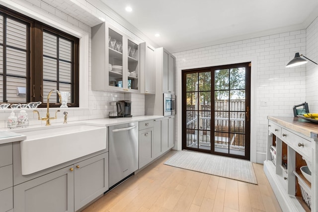 kitchen featuring light hardwood / wood-style floors, gray cabinetry, sink, and appliances with stainless steel finishes