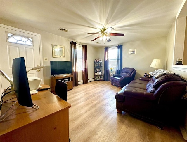 living room with a baseboard radiator, ceiling fan, and light hardwood / wood-style flooring