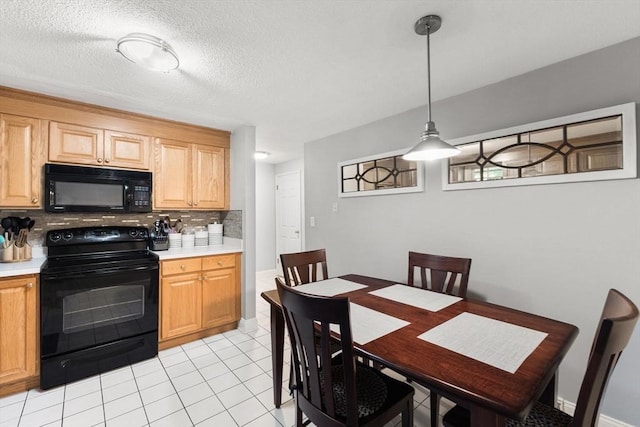 112 Cocasset St Unit 3, Foxboro, MA 02035 - kitchen with black appliances, tasteful backsplash, light countertops, light tile patterned flooring, and hanging light fixtures