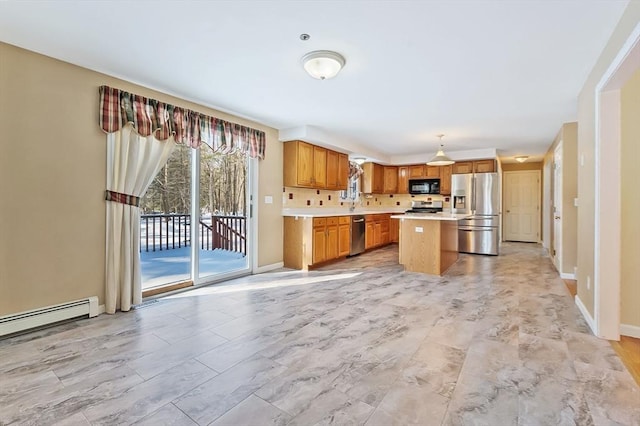 kitchen with a kitchen island, light countertops, brown cabinets, stainless steel appliances, and a baseboard radiator