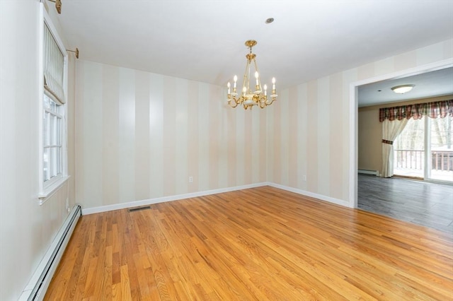 empty room featuring visible vents, baseboards, baseboard heating, and wallpapered walls