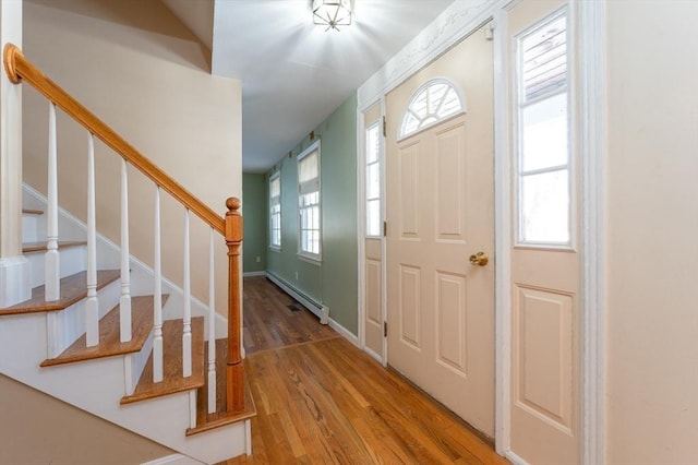 entrance foyer featuring stairs, wood finished floors, baseboards, and a baseboard radiator