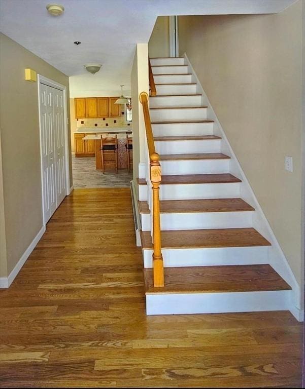 stairs featuring baseboards and wood finished floors