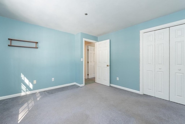 unfurnished bedroom featuring a closet, baseboards, and carpet