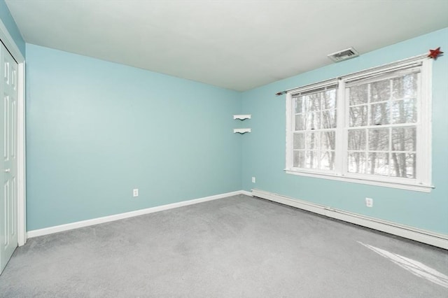 carpeted spare room with baseboard heating, baseboards, and visible vents