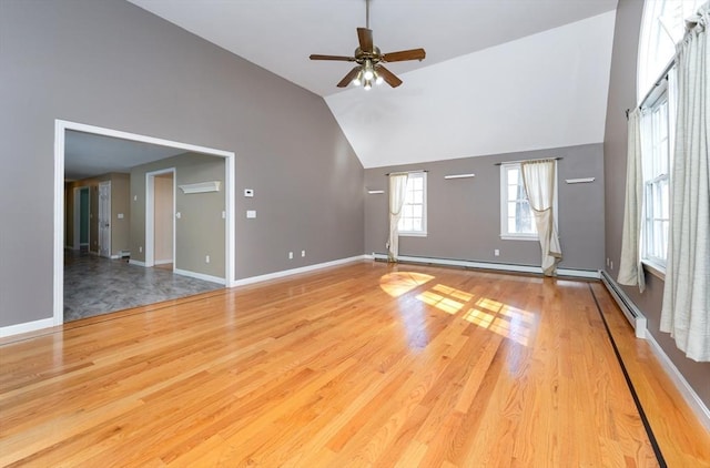 unfurnished living room with a ceiling fan, wood finished floors, baseboards, a wall mounted AC, and high vaulted ceiling