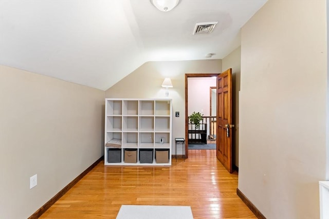 additional living space with vaulted ceiling and light hardwood / wood-style flooring