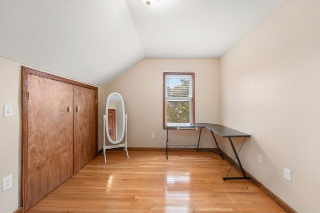 unfurnished office featuring vaulted ceiling and light wood-type flooring