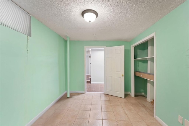 tiled spare room with a textured ceiling