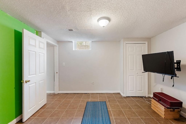 interior space featuring a textured ceiling and tile patterned flooring