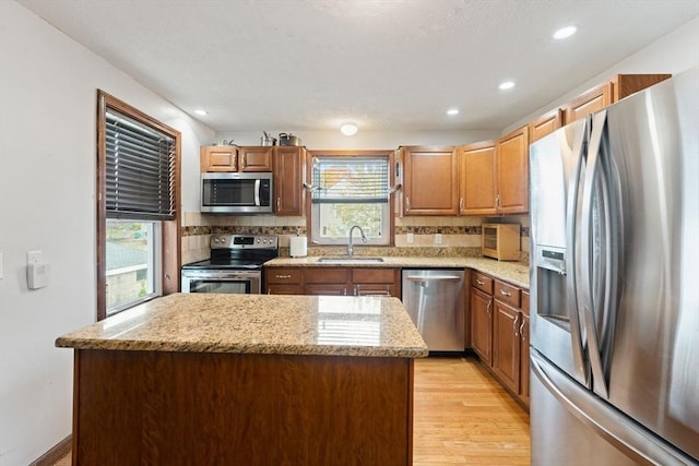 kitchen with decorative backsplash, sink, stainless steel appliances, and a center island