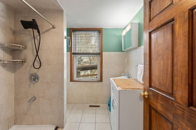 bathroom featuring sink, tile walls, tiled shower, and tile patterned flooring