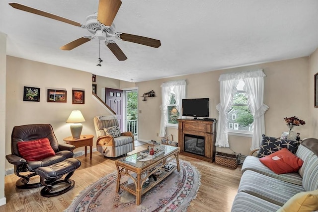 living room with light wood-type flooring and ceiling fan