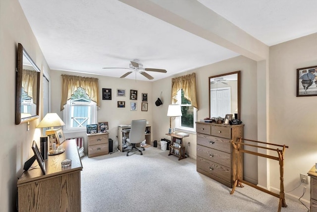 office area featuring ceiling fan, light colored carpet, and a healthy amount of sunlight