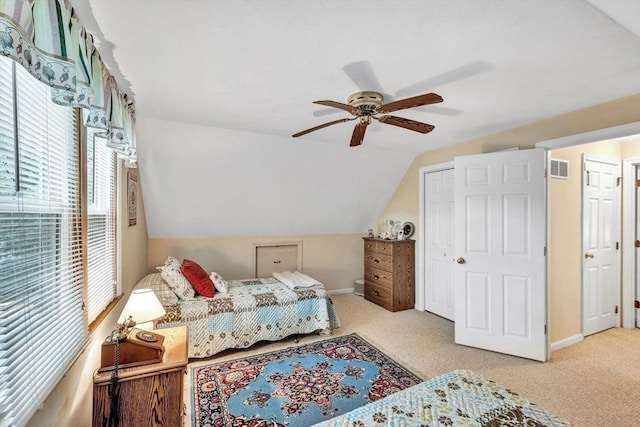 carpeted bedroom featuring ceiling fan, a closet, and lofted ceiling