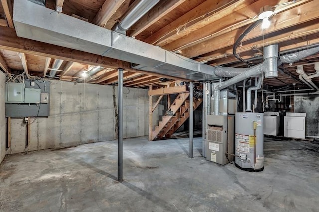 basement with gas water heater, heating unit, electric panel, and independent washer and dryer