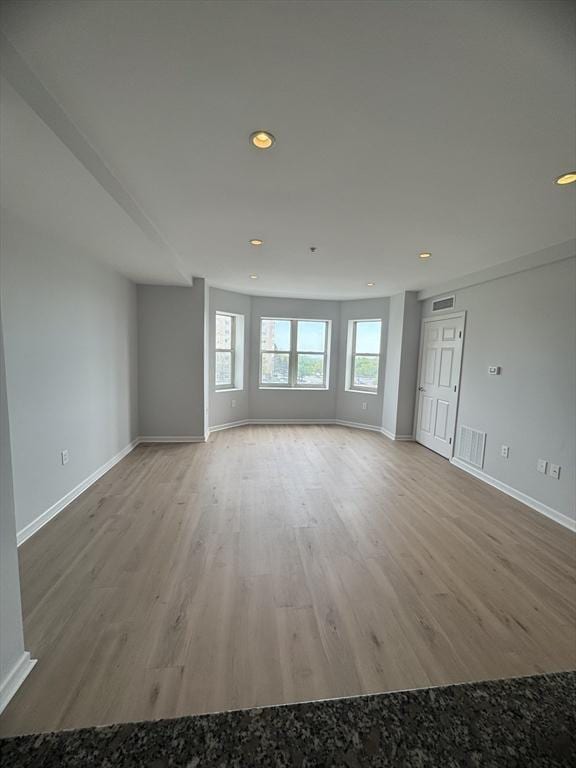 spare room featuring wood finished floors, baseboards, and recessed lighting