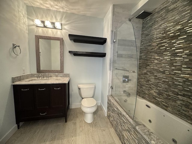 full bathroom with vanity, toilet, tiled shower / bath combo, baseboards, and wood finish floors